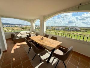 a dining room with a table and chairs and a large window at Beautiful apartment with golf and mountains view in Sucina