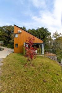 a house on a hill with a tree in the yard at Villa Alpina - Cabanas Conceito - Vale dos Vinhedos in Bento Gonçalves