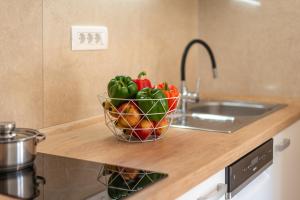 a bowl of fruit sitting on a counter next to a sink at Seaside Apartments Pinezic in Malinska +33 photos
