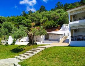 a house with stairs leading up to a house at Namastekala Holidays Studios in Chrysi Ammoudia