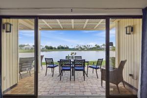a patio with a table and chairs and a view of the water at Stunning Sunset Scenes in Wesley Chapel