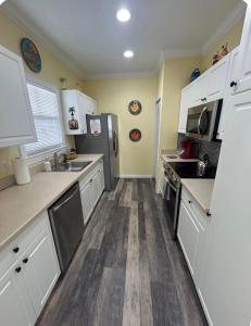 a kitchen with white cabinets and stainless steel appliances at Charming Key West Rental in Key West