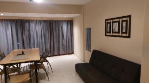 a living room with a couch and a table at Apart Hotel Costanera Colon in Colón