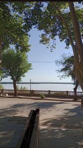 a park with trees and a fence next to the water at Apart Hotel Costanera Colon in Colón