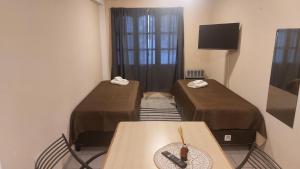 a room with two beds and a table and a television at Apart Hotel Costanera Colon in Colón