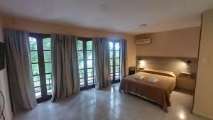 a bedroom with a bed and large windows at Apart Hotel Costanera Colon in Colón