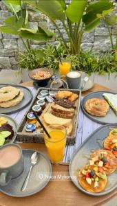 a table topped with plates of breakfast foods and drinks at Nuca Mykonos Hotel in Platis Gialos +129 photos