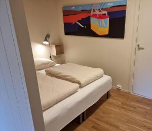 two beds in a room with a painting on the wall at Central apartment in Tromsø +2 photos