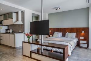 a bedroom with a large bed and a kitchen at Color Botánico in Buenos Aires