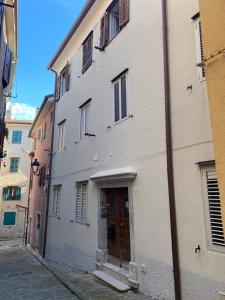 a white building with a door on a street at Casa Alice in Muggia