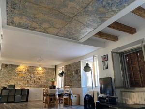 a living room with a ceiling with a stone wall at Casa Alice in Muggia