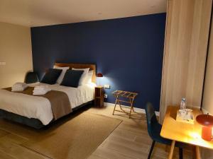 a bedroom with a bed and a blue wall at Domaine de la Brême in Bréménil