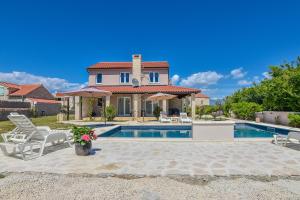 a villa with a swimming pool and a house at Casa di Marko-NEW MODERN RUSTIC HOUSE with pool AND SPACIOUS GARDEN! in Privlaka