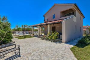 a house with a bench in front of it at Casa di Marko-NEW MODERN RUSTIC HOUSE with pool AND SPACIOUS GARDEN! in Privlaka