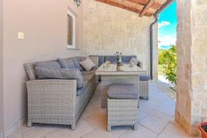 a patio with a couch and a table and chairs at Casa di Marko-NEW MODERN RUSTIC HOUSE with pool AND SPACIOUS GARDEN! in Privlaka