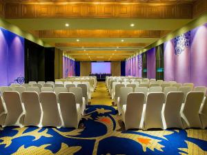 a conference room with white chairs and purple curtains at Grand Mercure Mysore - An Accor Brand in Mysore +135 photos
