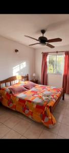 a bedroom with a bed and a ceiling fan at Cabañas del bosque in Merlo