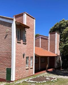 a red brick building with a red roof at Cabañas del bosque in Merlo