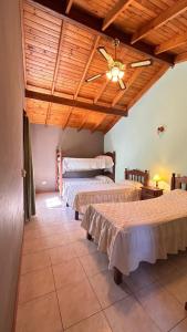 a bedroom with three beds and a wooden ceiling at Cabañas del bosque in Merlo