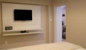 a bedroom with a flat screen tv on a wall at Casa da Ópera in Diamantina