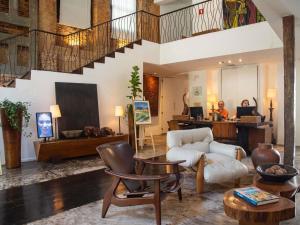 a man sitting at a desk in a living room at Santa Teresa Hotel Rio de Janeiro - MGallery Collection in Rio de Janeiro