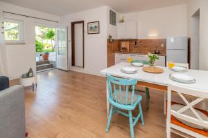 a kitchen with a white counter and blue chairs at Seaside Apartments Pinezic in Malinska