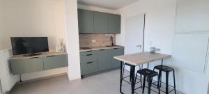 a kitchen with blue cabinets and a table and stools at L'Appar-TMN in Challans