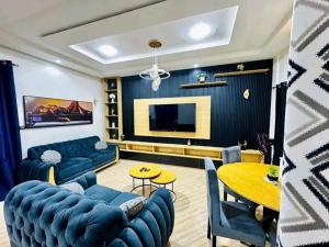 a living room with a blue couch and a table at Appartement meublé service in Cotonou +6 photos