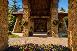 a entrance to a building with flowers in front at Aurora Resort & Spa in Berovo +129 photos
