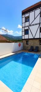 a swimming pool in front of a building at Apartamentos La Iguana in Hervás