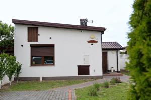 a white house with a brown door at Domek w Starym Mieście in Stare Miasto