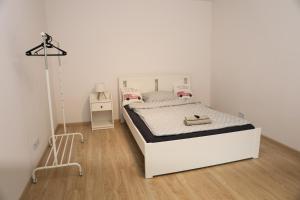 a white bedroom with a white bed and a lamp at Domek w Starym Mieście in Stare Miasto