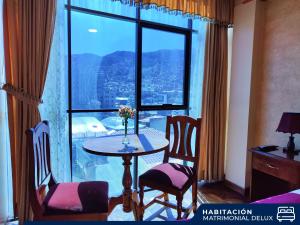 a room with a table and chairs and a large window at Hotel Diamante Azul in La Paz