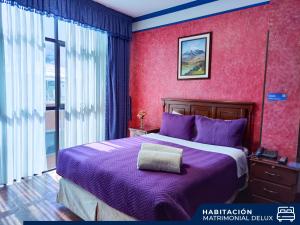 a bedroom with a purple bed with a purple blanket at Hotel Diamante Azul in La Paz