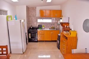 a kitchen with a white refrigerator and wooden cabinets at Las Magnolias in Embalse