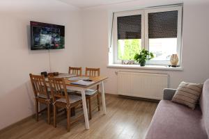 a living room with a table and chairs and a couch at Domek w Starym Mieście in Stare Miasto