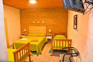 a bedroom with two beds and two chairs at Las Magnolias in Embalse