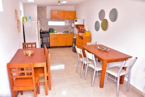 a kitchen with a table and chairs and a refrigerator at Las Magnolias in Embalse +7 photos