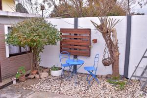 a patio with two chairs and a table next to a wall at Las Magnolias in Embalse