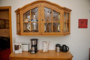 a wooden cabinet with glass doors on a table at Aparthaus Schmiedeschenke in Dresden