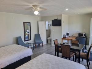 a hotel room with a bed and a table and chairs at Manor Motel in Southampton