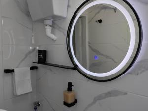 a bathroom with a large mirror on the wall at Little Kristi in Palaiókastron +25 photos