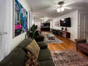 a living room with a couch and a flat screen tv at Spacious Napoleon Ave Condo in New Orleans