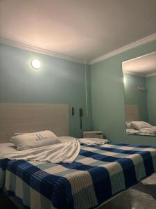 a bedroom with a bed with a blue and white blanket at Hotel Romanza in Bogotá +5 photos