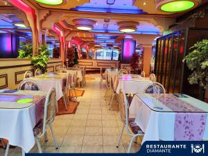 a restaurant with white tables and chairs in a room at Hotel Diamante Azul in La Paz