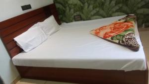 a bed with a wooden headboard and a pillow on it at OM DAYAMA Please in Khātu