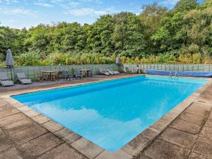 a swimming pool with a patio and tables and chairs at 2 Bed in Saltash oc-95642 in Wotter