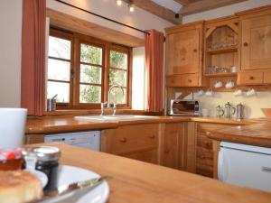 a kitchen with wooden cabinets and a sink and a window at 1 Bed in Somerton oc-asher in Compton Dando