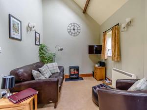 a living room with leather couches and a wood stove at 1 Bed in York oc-83265 in High Catton