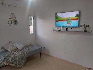a living room with a bed and a flat screen tv at Nido del Sol in Pocito